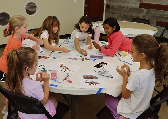 Children working on an art project sitting at a table.