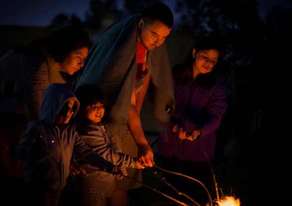 Photo of family sitting around a campfire