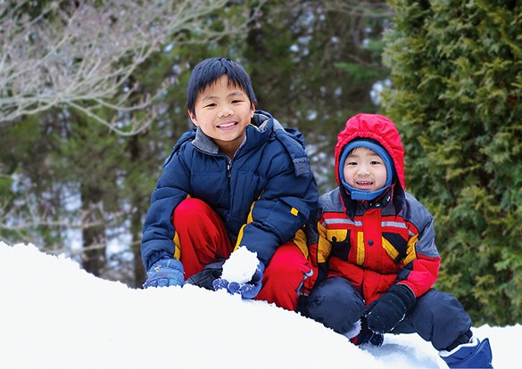 Two young boys playing in the snow