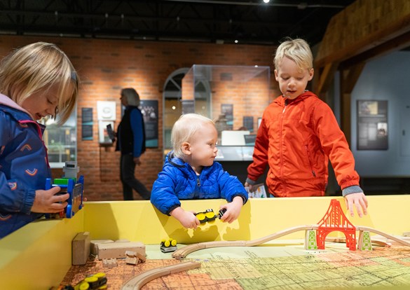 Children playing with a wooden train set during the Sensory-Friendly Hour