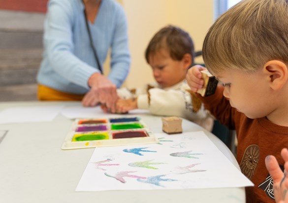 Instructor teaching young children how to paint.