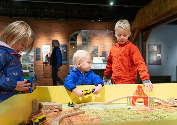 Children playing with a wooden train set during the Sensory-Friendly Hour