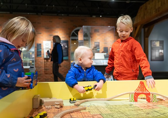 Children playing with a wooden train set during the Sensory-Friendly Hour