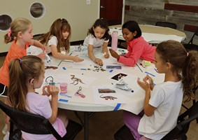 Children working on an art project sitting at a table.