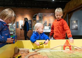 Children playing with a wooden train set during the Sensory-Friendly Hour