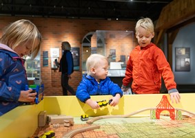 Children playing with a wooden train set during the Sensory-Friendly Hour