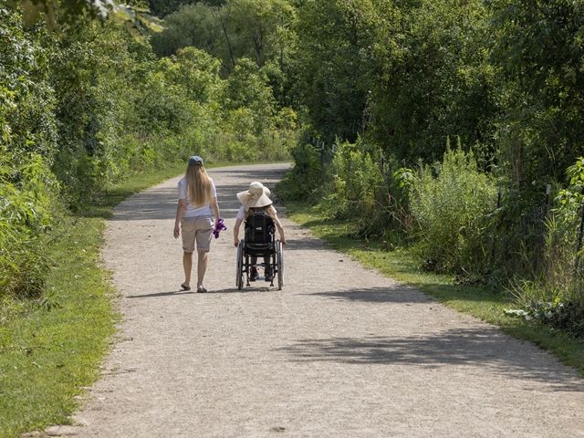 Woman and a friend in a wheel chair on an accessible trail