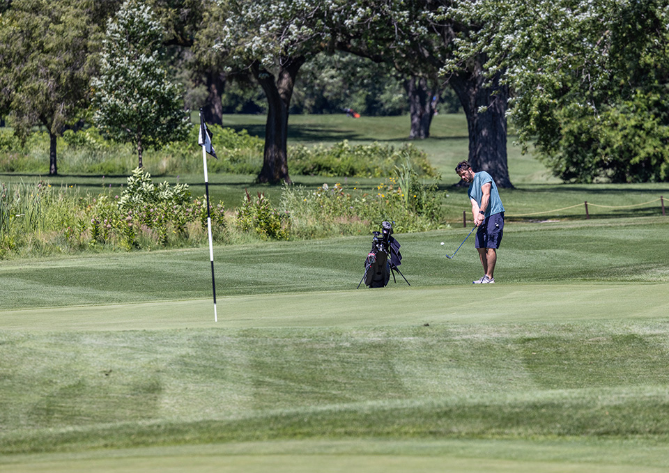 Golfer at Brae Loch Golf courses hitting on the green near the tee.