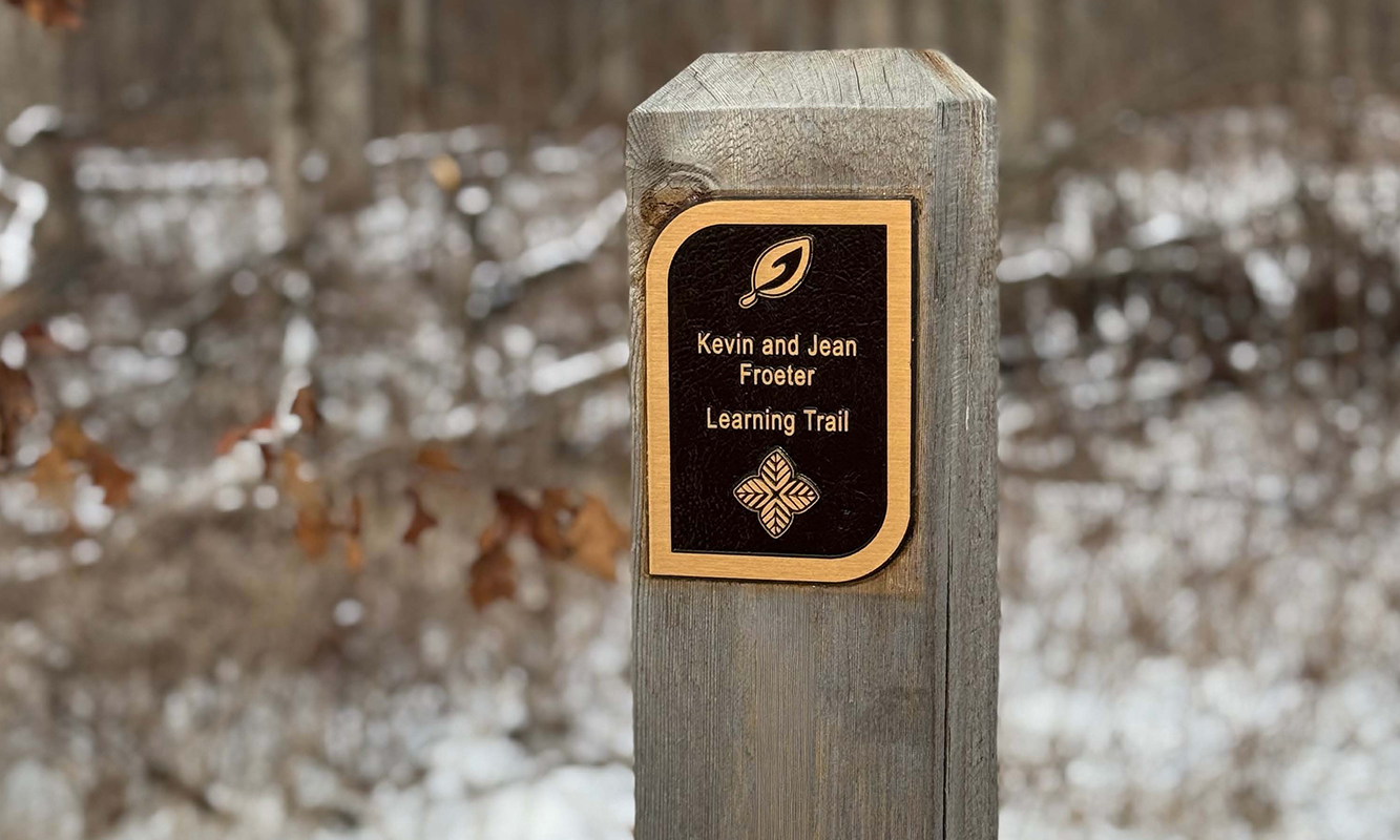 Commemorative plaque on trail post.