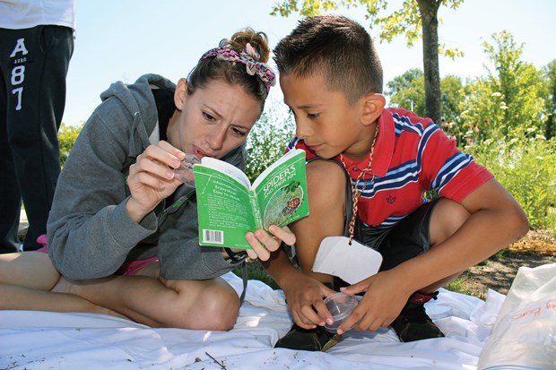 Instructor showing a student a book on animal species