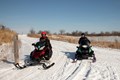 Photo of a pair of snowmobiles riding the trails