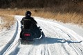 Photo of snowmobile riding on snow covered trails