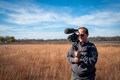 Environmental communication specialist Brett Peto filming in the forest preserve.