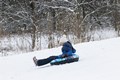 Young girl going down the hill on a sled tube