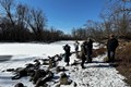 Volunteer photographers shooting photos along a frozen river bank.