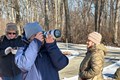 Volunteer photographers walking through the woods taking photos.