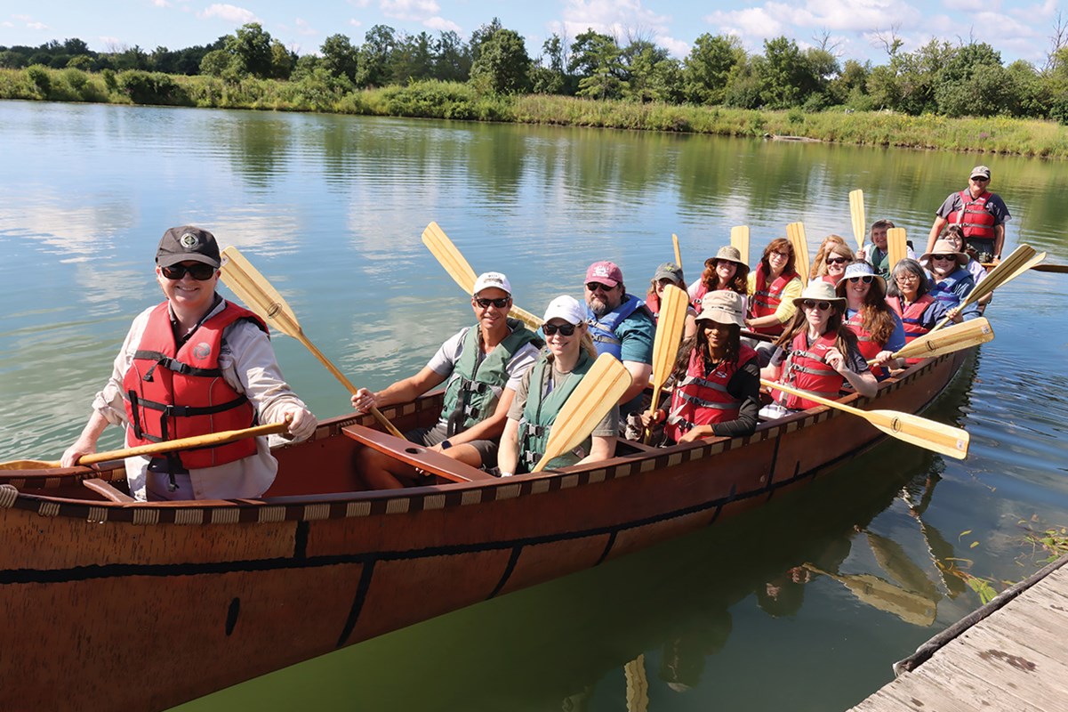 Group of teachers paddling a large canoe on Teacher Appreciation Day