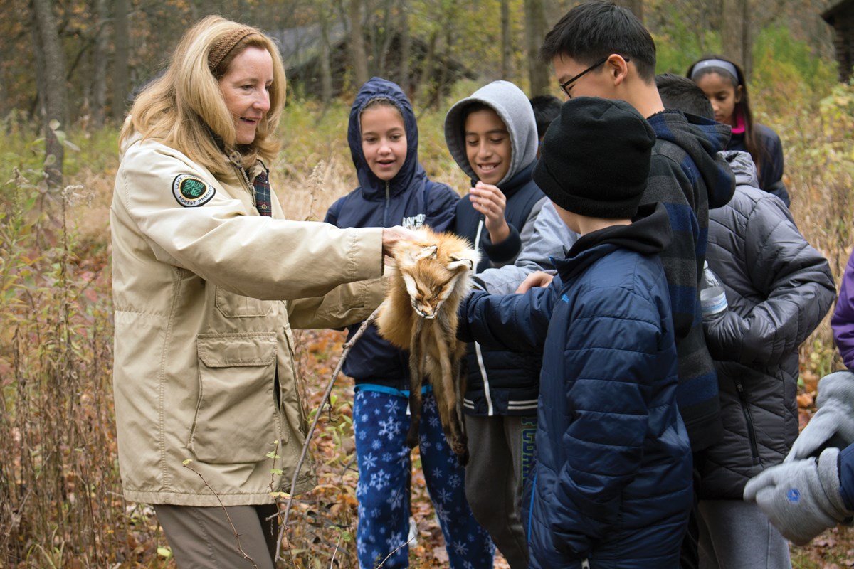 Instructor showing a group of child an animal pelt