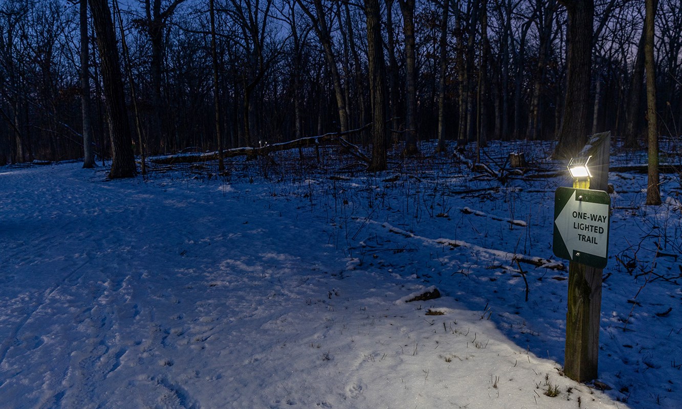 Solar-lit trail sign at night